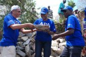 Angelina Wapakhabulo, Uganda High Commissioner for Kenya (centre) helps Apollo Group CEO, Mr. Ashok Shah, (left) together with Mr. Michael Oduor, Chief Executive Officer of APA Insurance (right) build a sand dam. sand dam