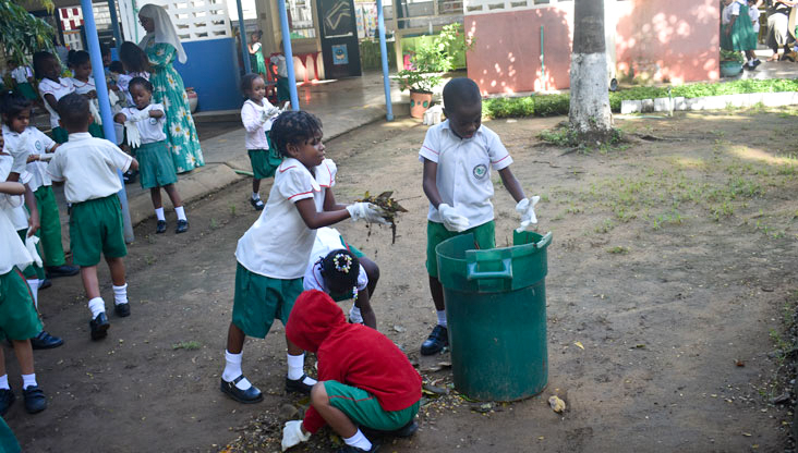 AKNS, Mombasa students cleaning up the playground by collecting leaves