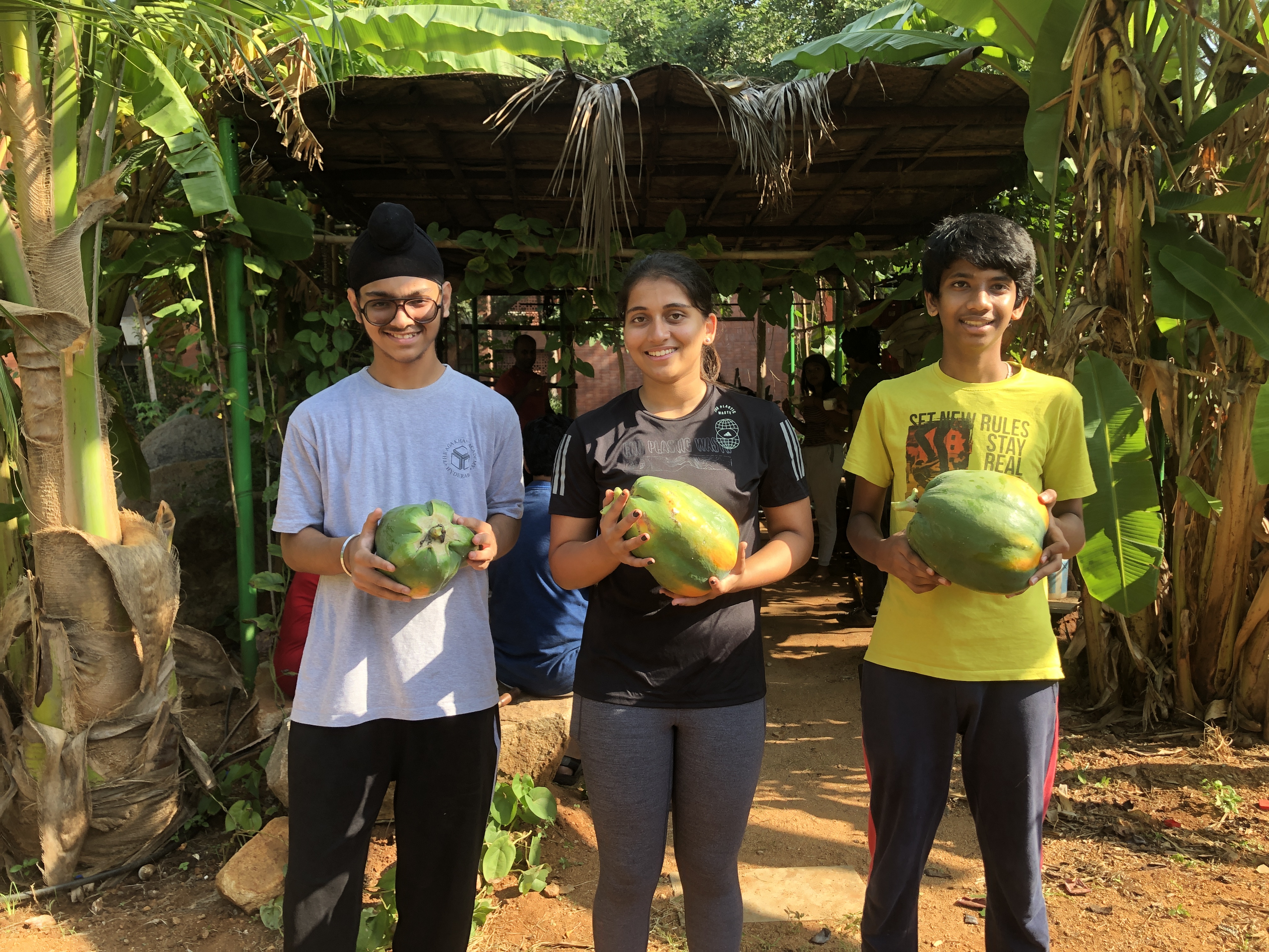 Picture of AKA Hyderabad students holding fruits and veg grown in a farm