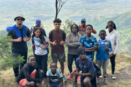 AKA Mombasa and some exchange students at the top of a mountain with a view of green countryside in the background