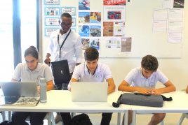 Students sitting at a table on laptops